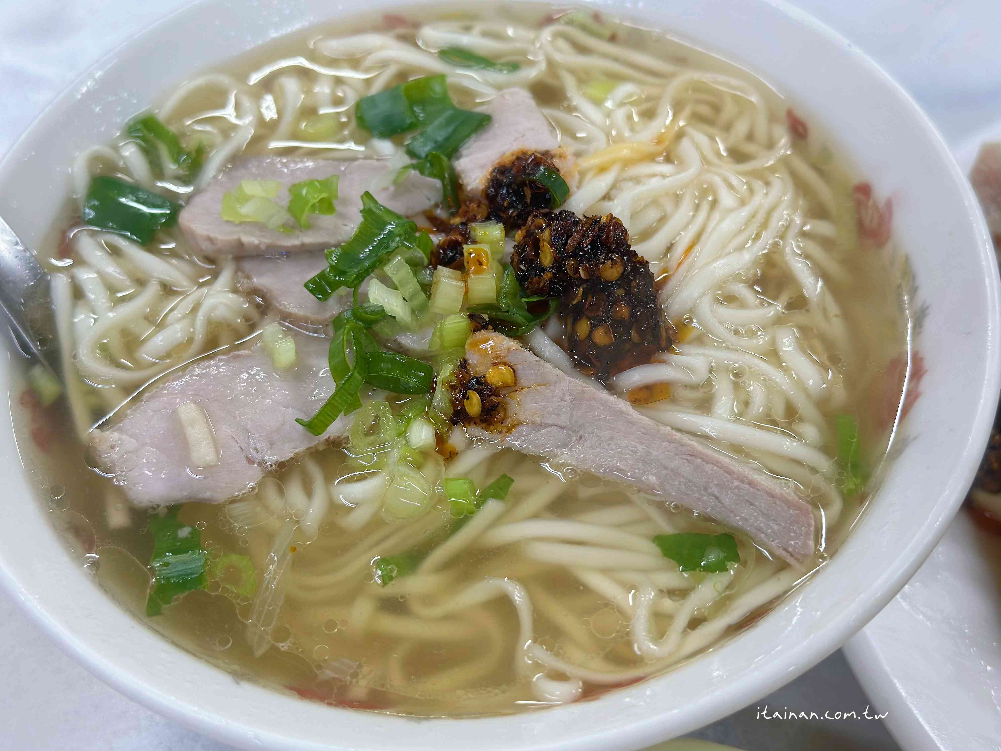 一口豬油香乾拌麵配上一顆肉包，手工真味勾回記憶裡的台南老味道，飄香逾一甲子的「大菜市包仔王」